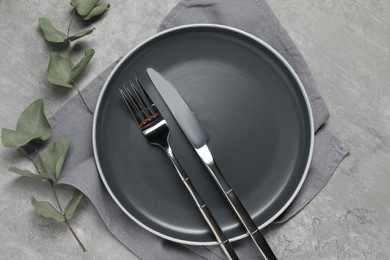 Stylish setting with elegant cutlery on grey table, top view