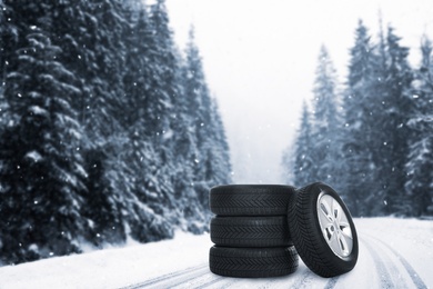 Image of Set of wheels with winter tires outdoors on snowy road 