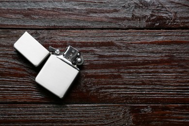 Gray metallic cigarette lighter on wooden table, top view. Space for text