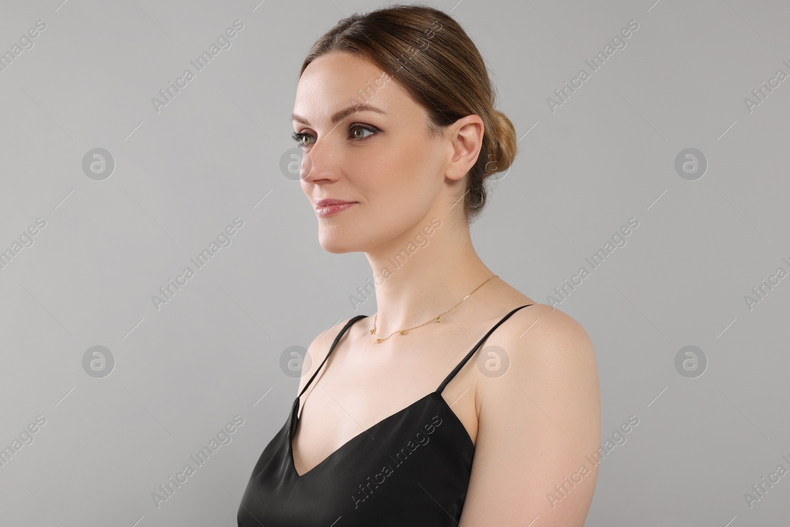 Photo of Beautiful woman with elegant necklace on light grey background