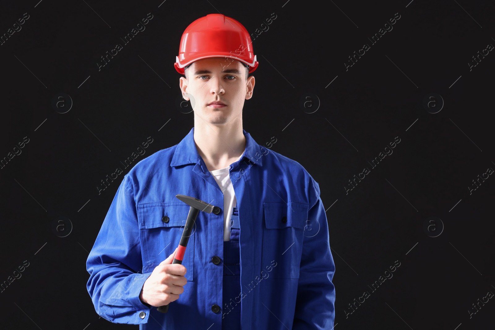 Photo of Professional repairman holding hammer on black background. Space for text