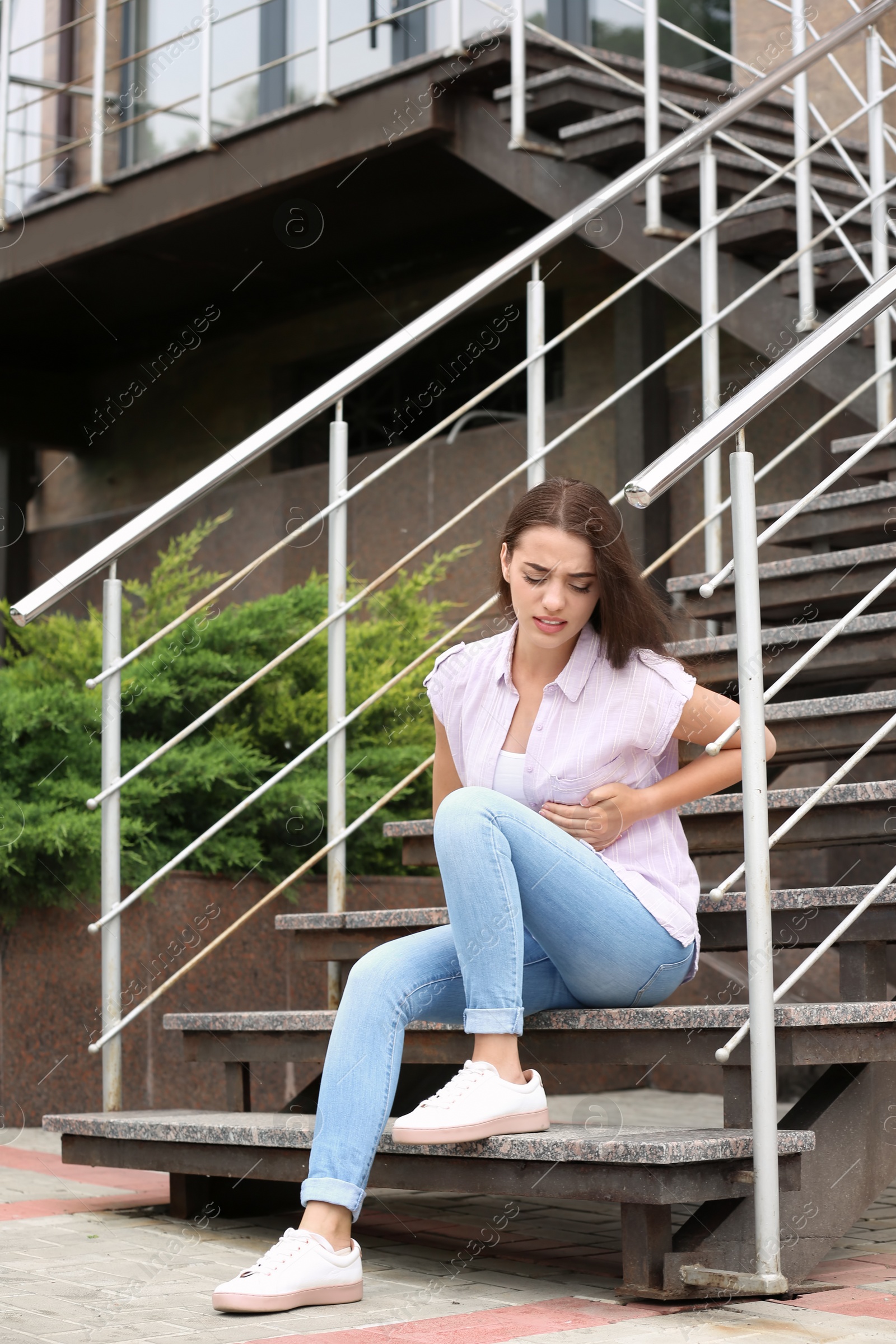 Photo of Young woman having chest pain outdoors. Heart attack