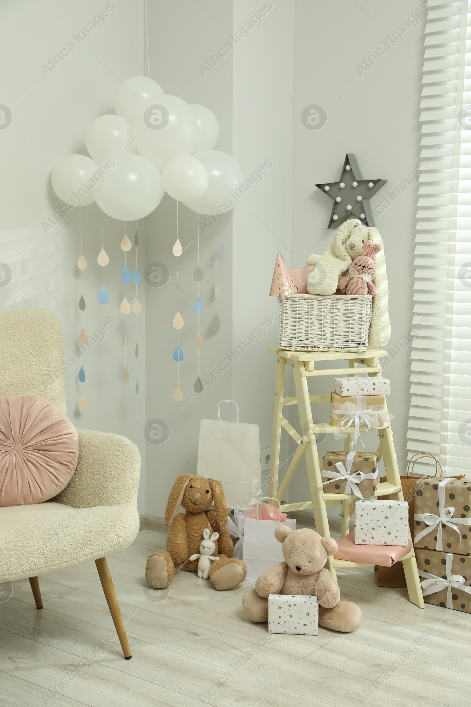 Photo of Baby shower party. Festive decor, gift boxes and toys in stylish room