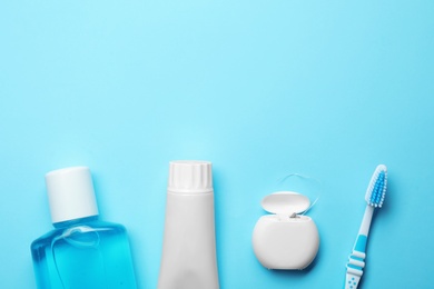 Photo of Flat lay composition with toothpaste, oral hygiene products and space for text on color background