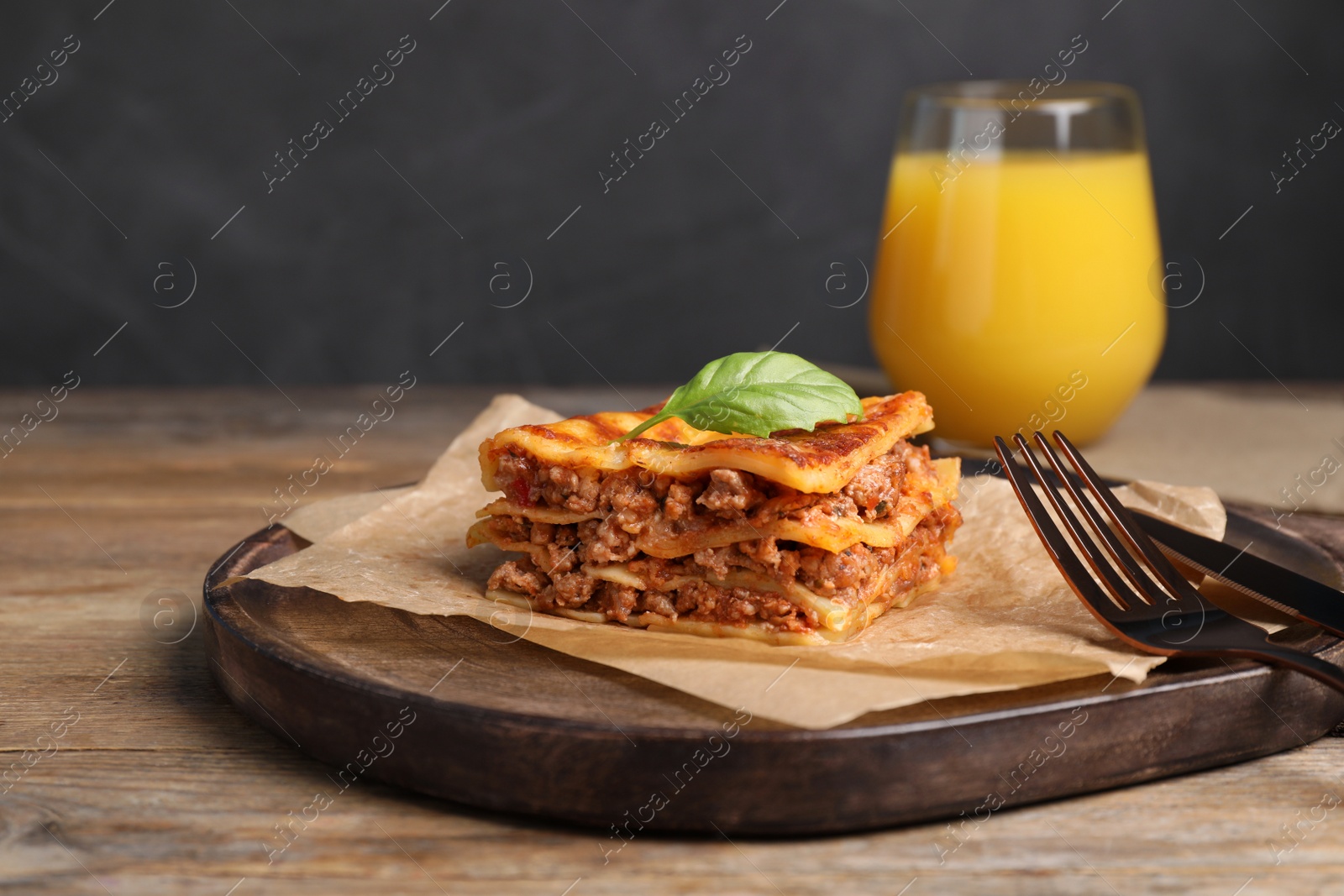 Photo of Tasty cooked lasagna served on wooden table