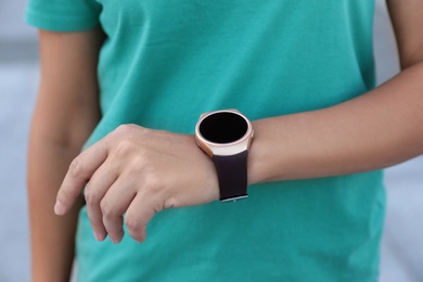 Photo of Woman with modern smart watch outdoors, closeup