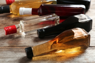 Photo of Bottles with different kinds of vinegar on wooden table