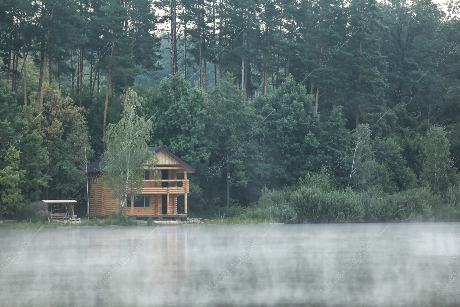 Photo of Beautiful landscape with forest and house near lake. Summer camp location