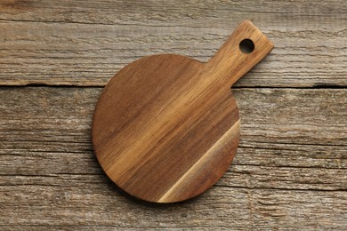 Photo of One new cutting board on old wooden table, top view