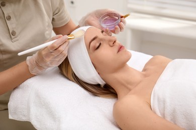 Photo of Young woman during face peeling procedure in salon