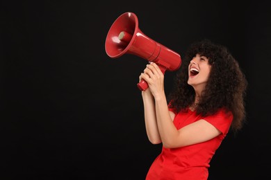 Photo of Happy fan using megaphone on black background, space for text