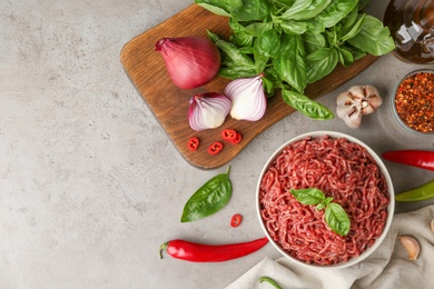 Flat lay composition with fresh raw minced meat on light table. Space for text