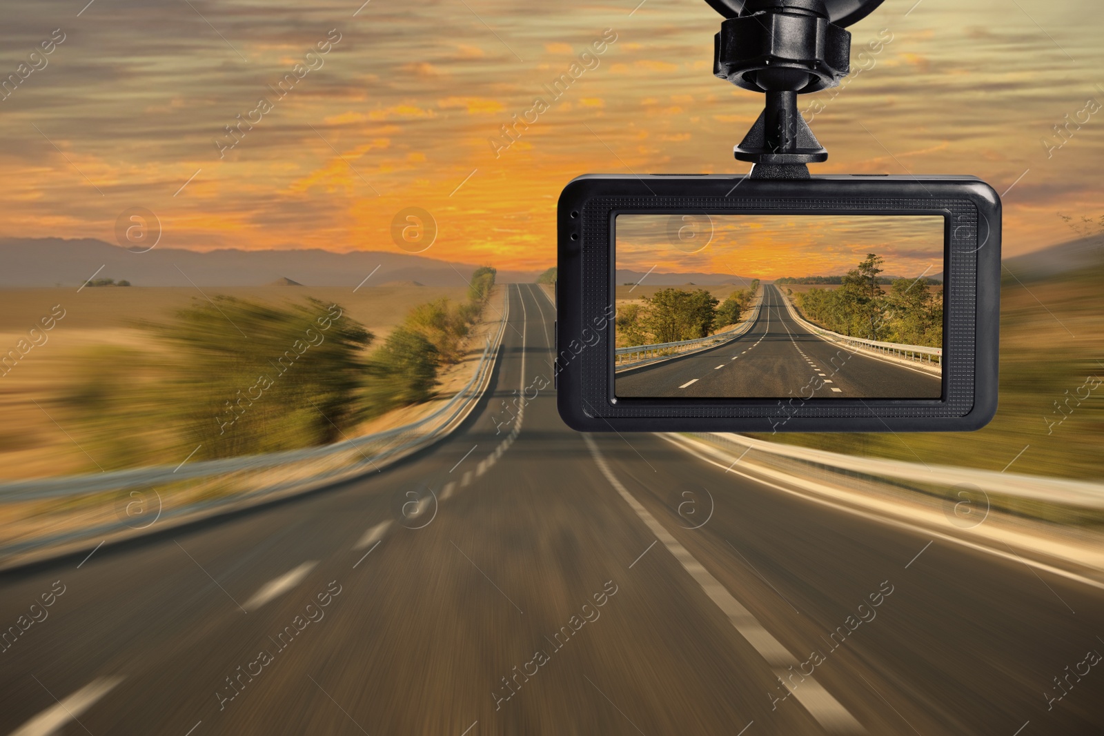 Image of Modern dashboard camera mounted in car, view of road during driving