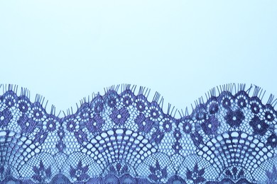 Photo of Beautiful lace on light blue background, top view. Space for text