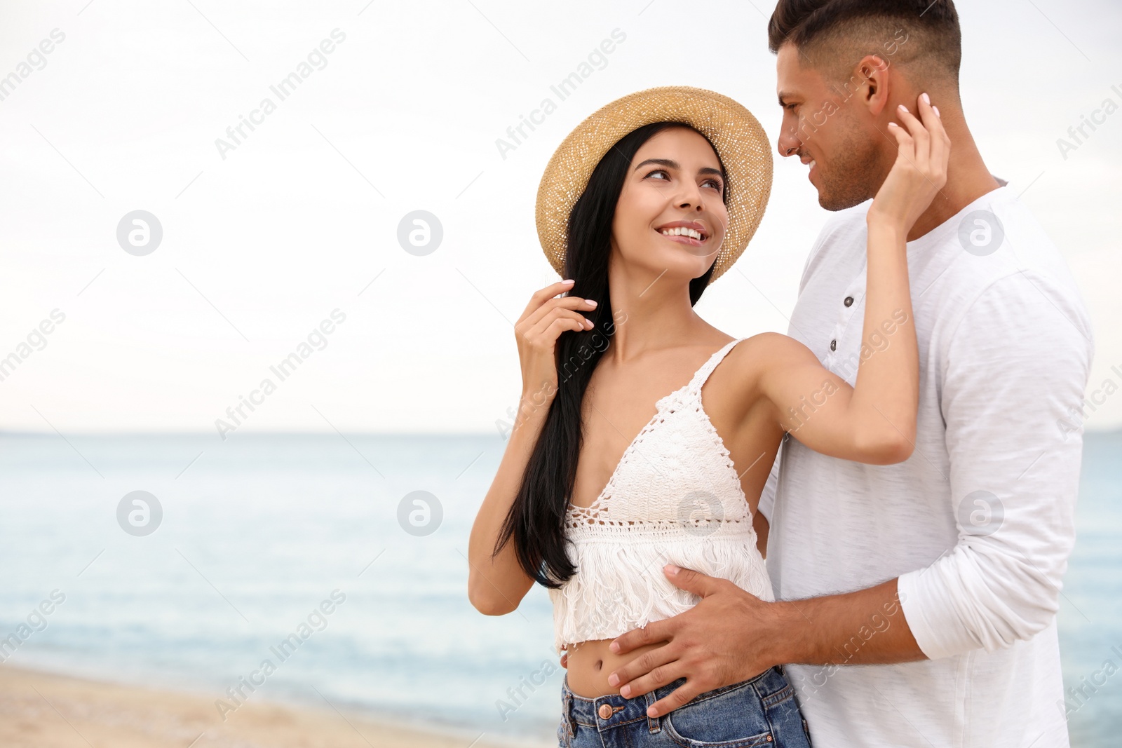 Photo of Lovely couple spending time together on beach. Space for text