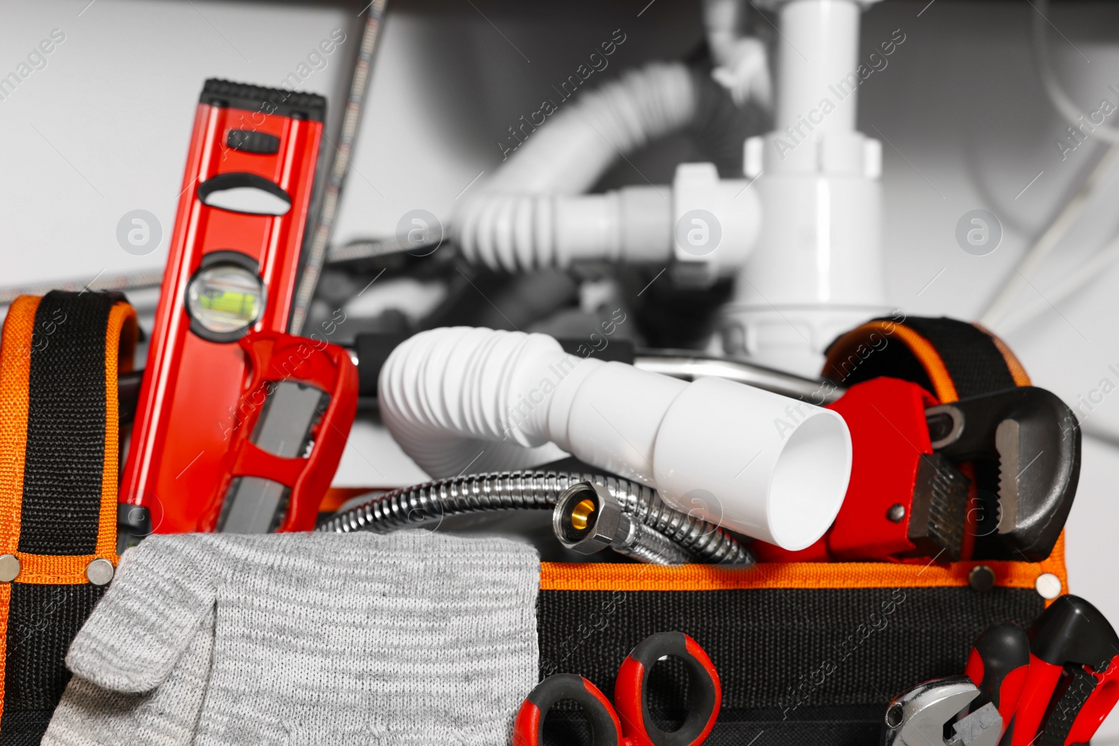 Photo of Plumber's bag with different tools indoors, closeup