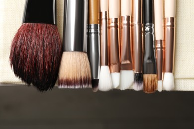Photo of Set of different makeup brushes drying after cleaning on table, flat lay