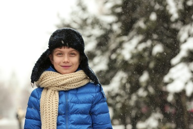 Photo of Portrait of little boy outdoors on snowy day. Space for text