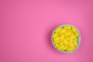 Photo of Delicious lemon drops on pink background, top view. Space for text