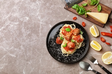 Photo of Delicious pasta with meatballs and tomato sauce on grey background, flat lay