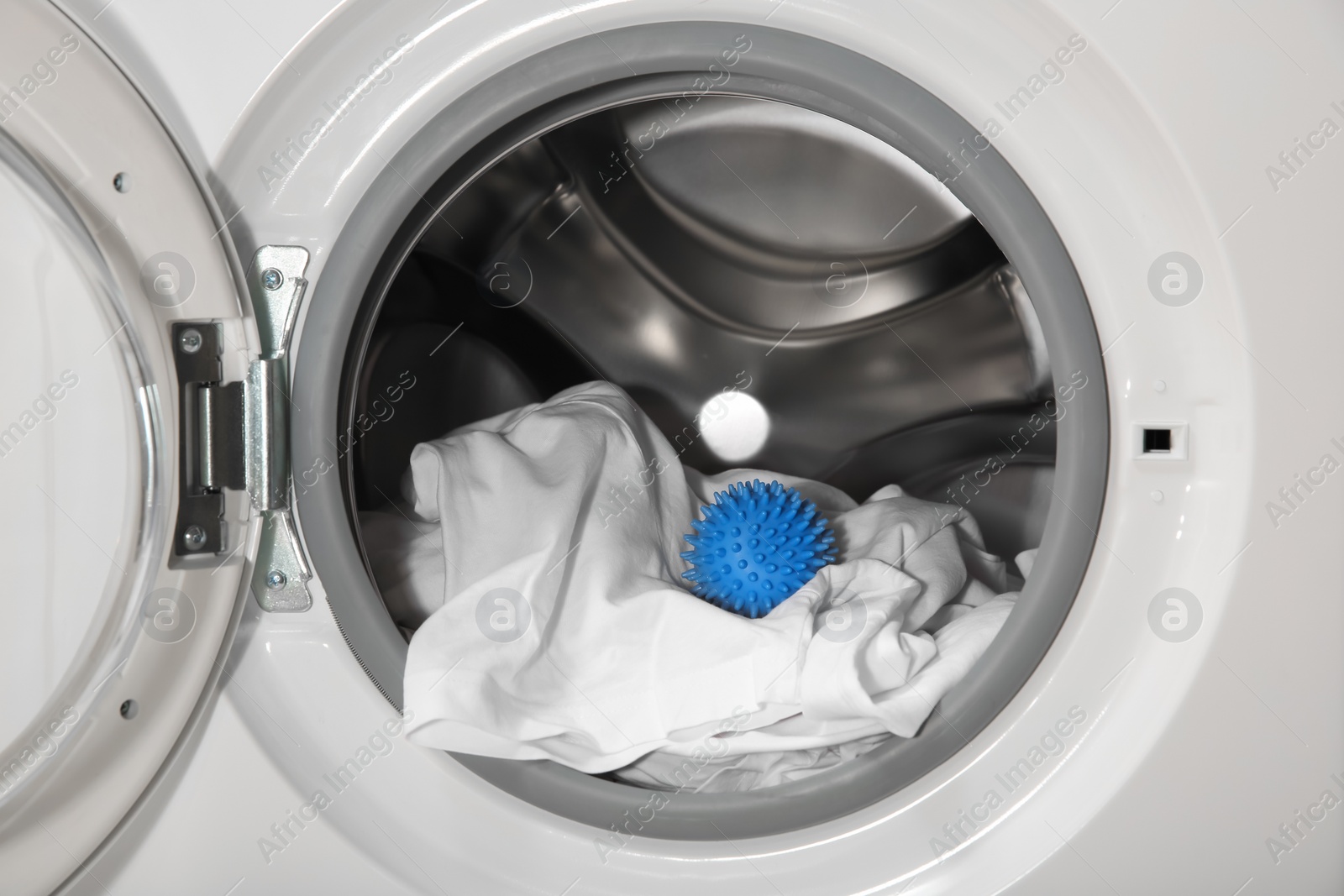 Photo of Blue dryer ball and clothes in washing machine drum