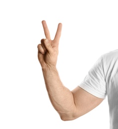 Young man showing victory gesture on white background