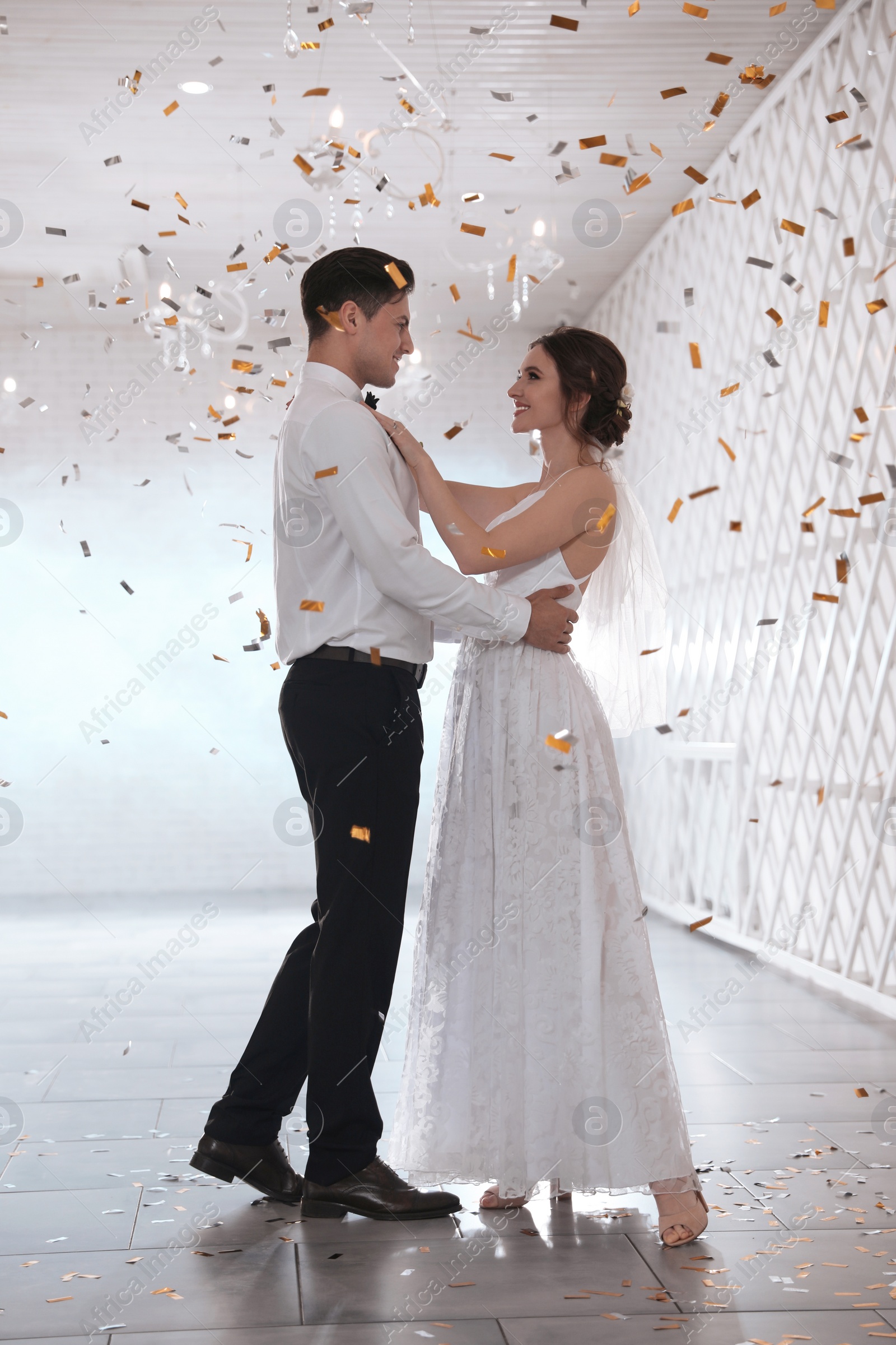 Photo of Happy newlywed couple dancing together in festive hall