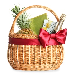 Photo of Wicker basket full of gifts isolated on white