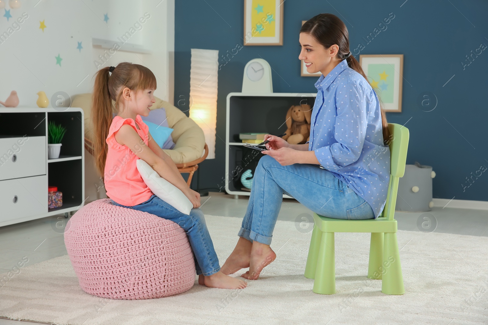 Photo of Female psychologist working with cute little girl in office