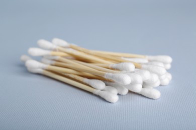 Wooden cotton buds on light grey background, closeup