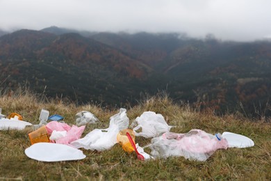 Photo of Plastic garbage scattered on grass in nature