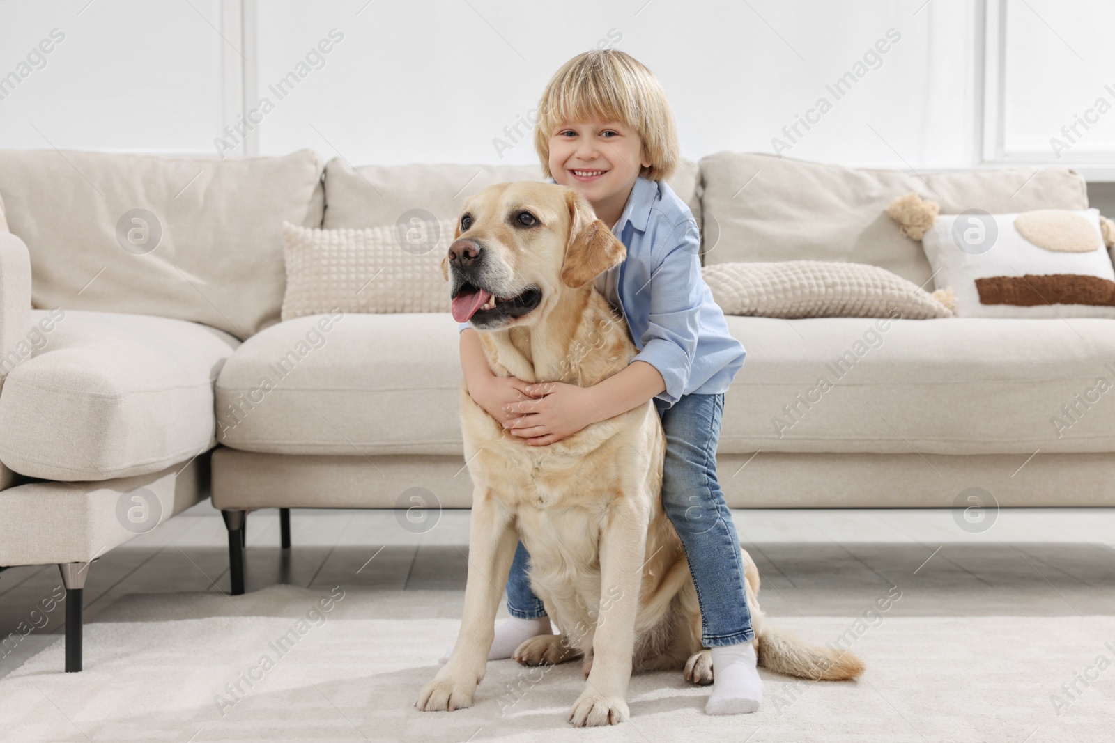 Photo of Cute little child with Golden Retriever at home. Adorable pet