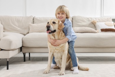 Cute little child with Golden Retriever at home. Adorable pet