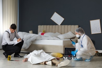 Photo of Investigators working at crime scene with dead body