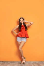 Photo of Full length portrait of beautiful woman with sexy legs near color wall