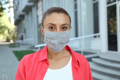 Photo of Woman wearing handmade cloth mask outdoors. Personal protective equipment during COVID-19 pandemic