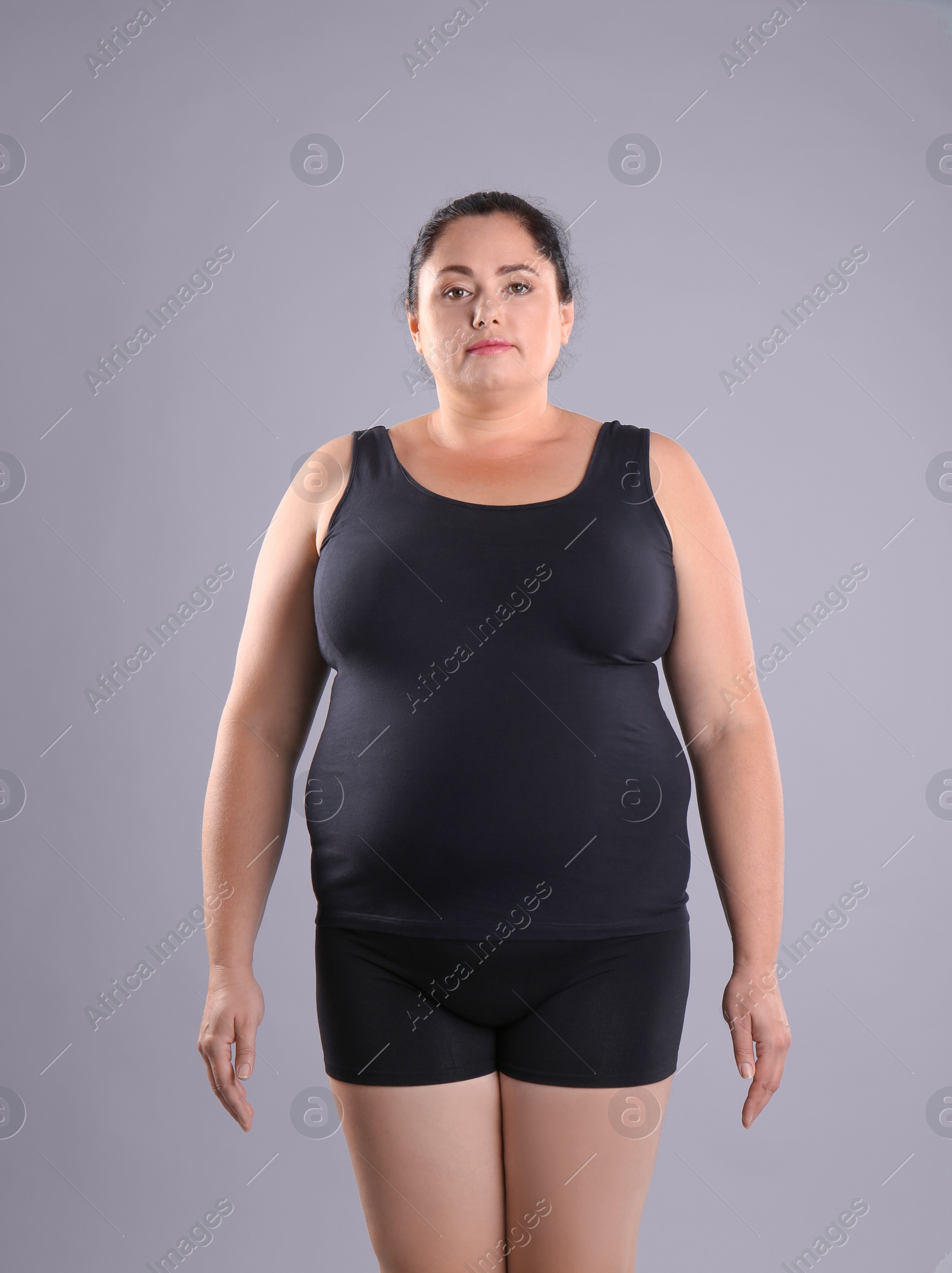 Photo of Fat woman on grey background. Weight loss