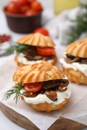 Photo of Delicious profiteroles with cream cheese, mushrooms, tomato and dill on board, closeup