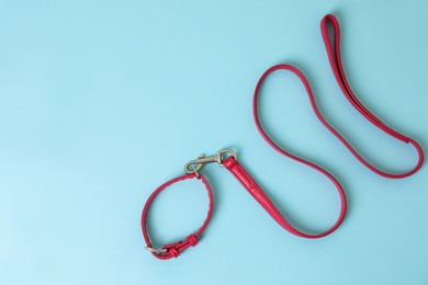 Photo of Red leather dog leash on light blue background, top view. Space for text