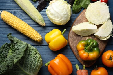 Photo of Fresh ripe vegetables on blue wooden table, flat lay