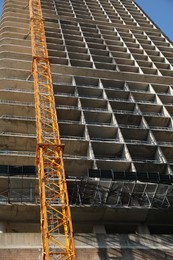 Photo of Modern unfinished multistory building against blue sky, low angle view