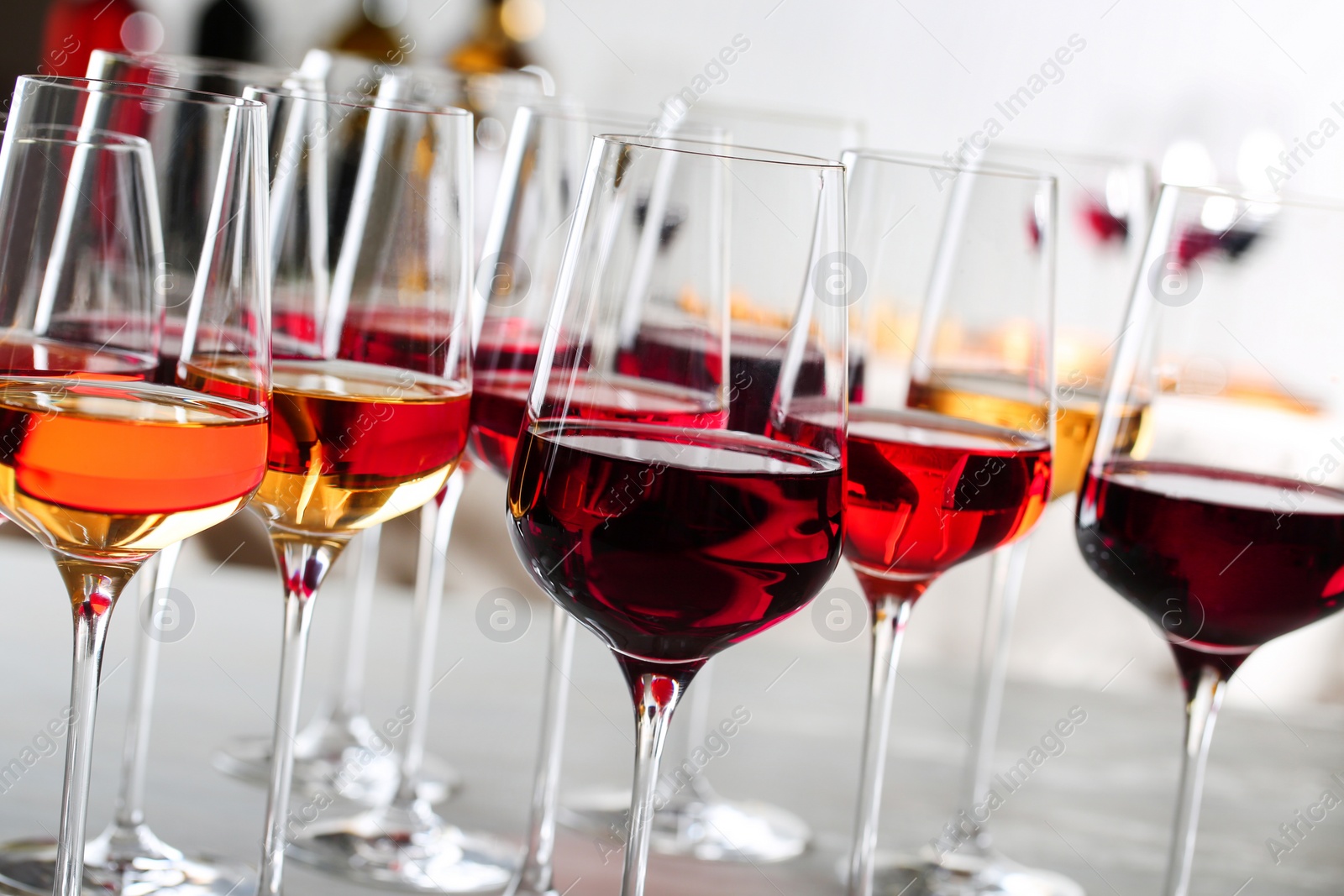 Photo of Glasses with different wines on blurred background, closeup