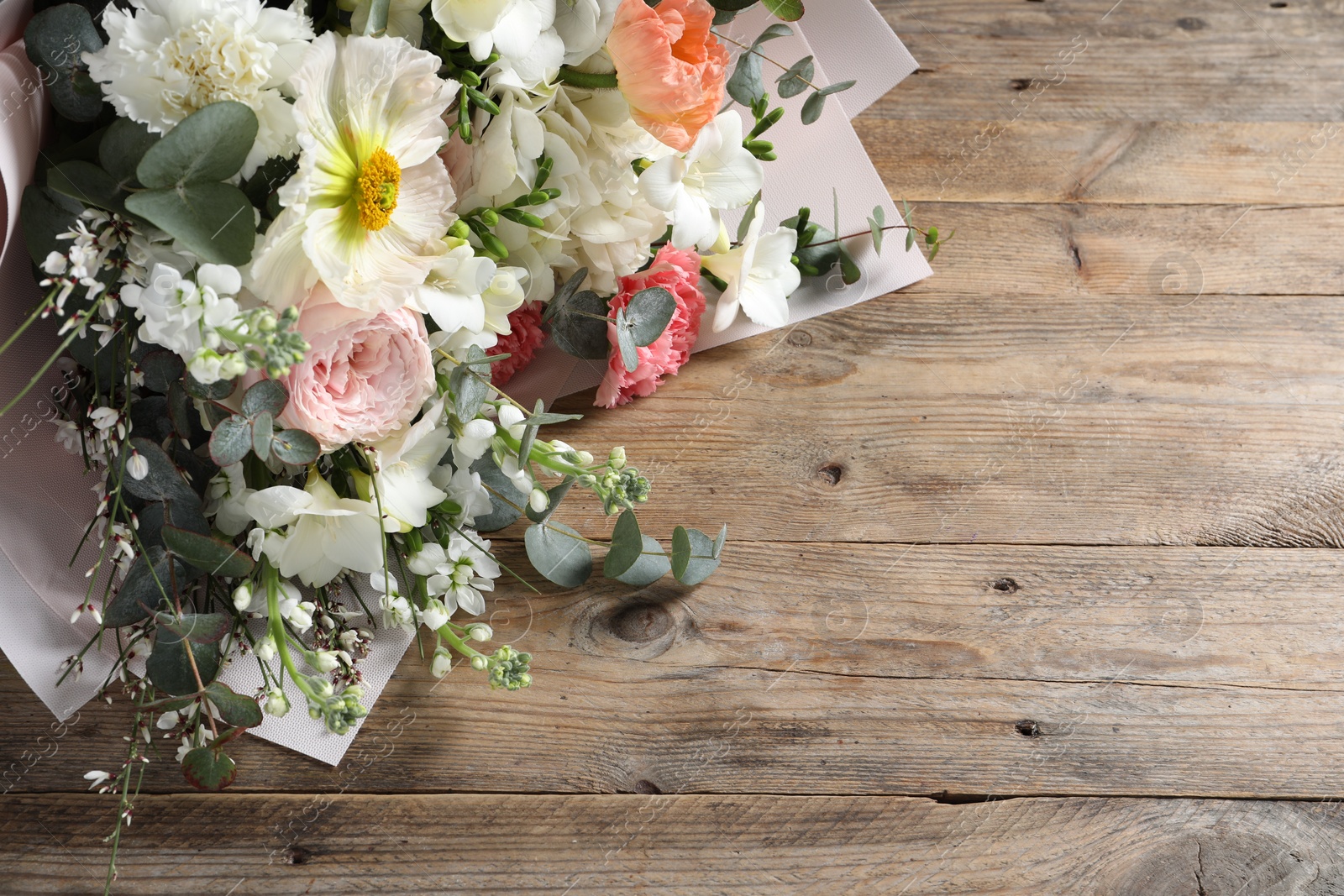 Photo of Bouquet of beautiful flowers on wooden table, above view. Space for text