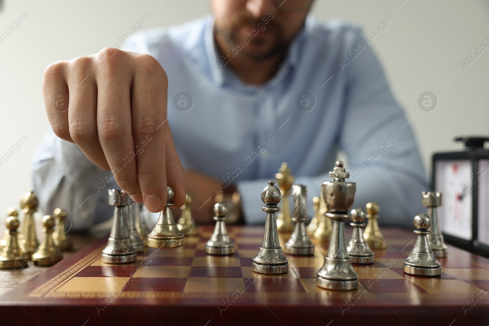 Photo of Man playing chess during tournament at chessboard, closeup