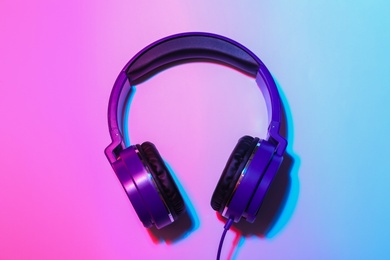 Photo of Stylish headphones on color background, top view