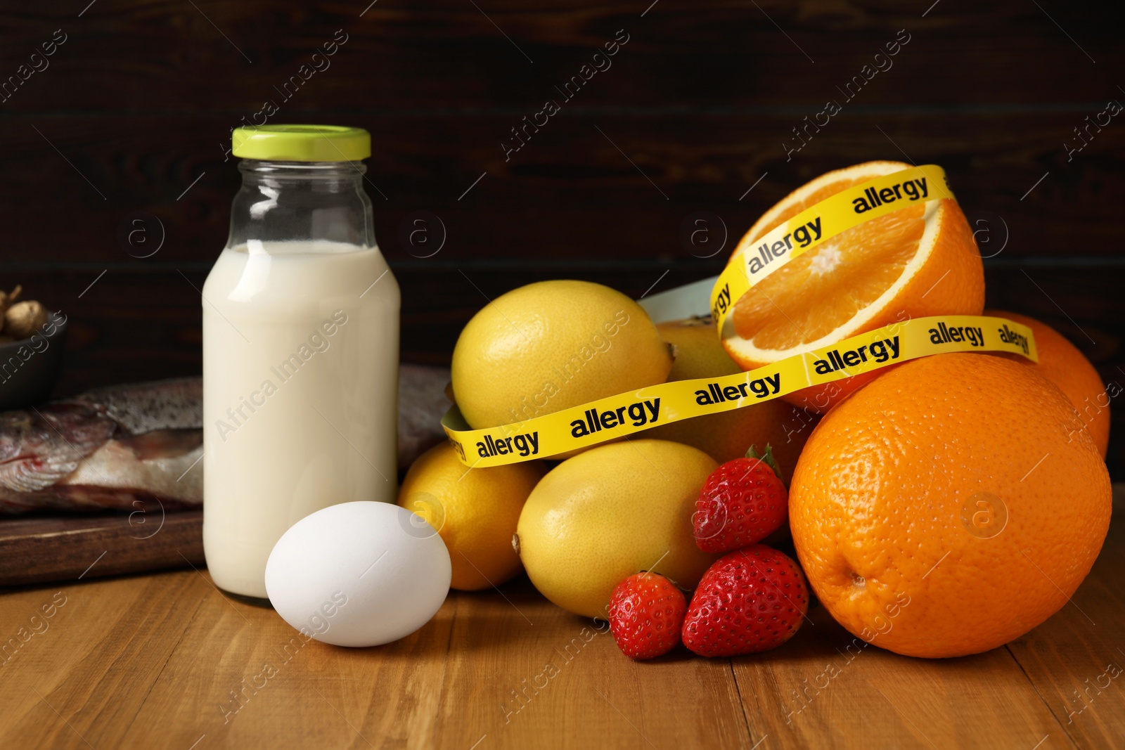 Photo of Allergenic food. Different fresh products with tape on wooden table, closeup