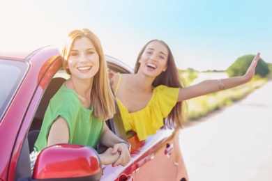 Happy beautiful young women together in car