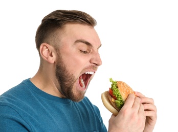 Photo of Young man eating tasty burger on white background