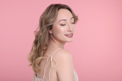 Portrait of smiling woman on pink background