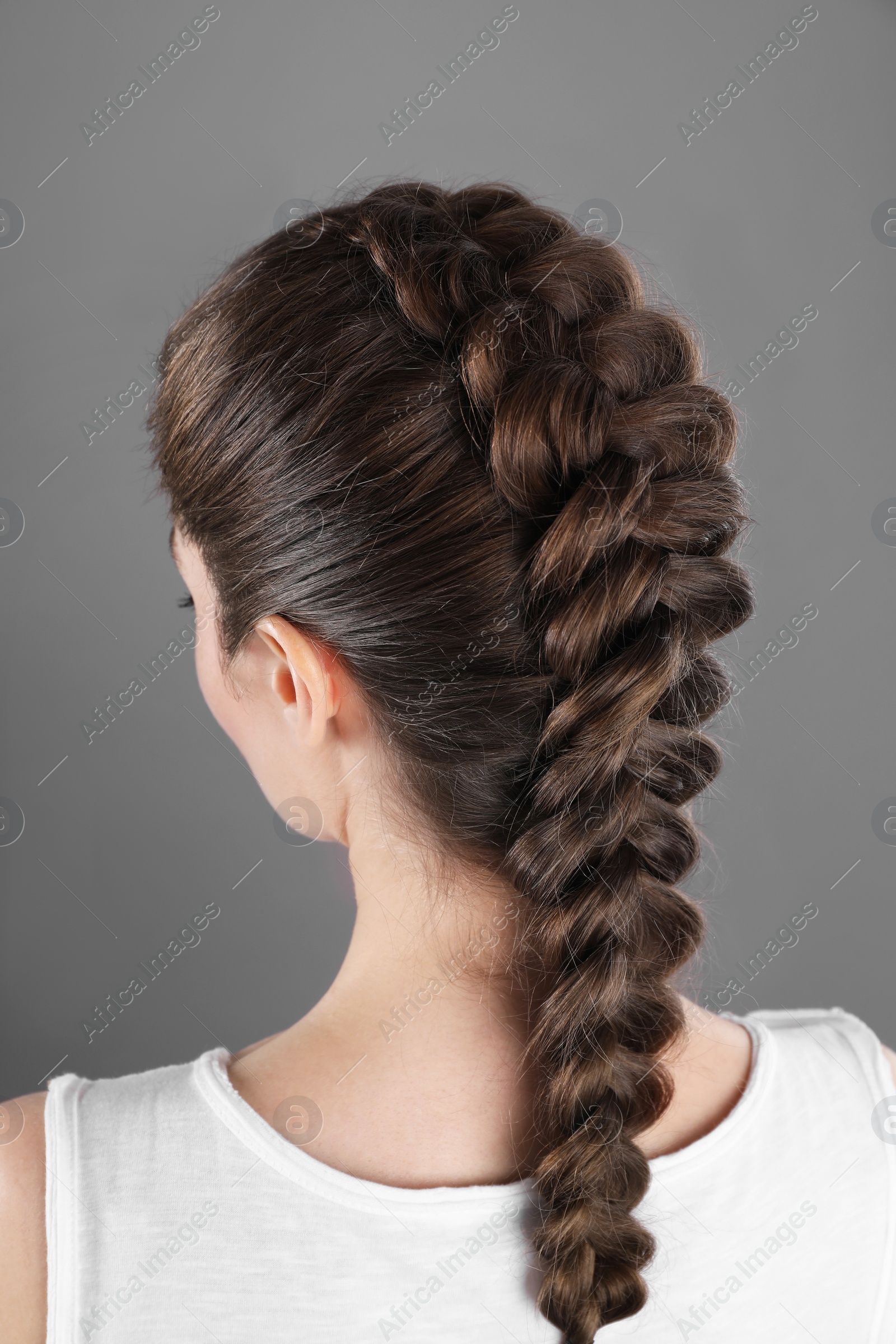 Photo of Woman with braided hair on grey background, back view